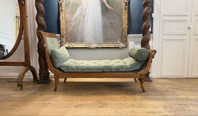 un banc dans une pièce où est accroché un tableau au mur