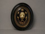 black and gold plate with a picture of a lady in a wreath