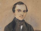 portrait of a man in a suit and bow tie with his arms crossed