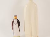 a figurine of a monk and a bottle of wine