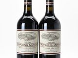 two bottles of red wine sitting next to each other on a table