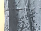 a black and white photo of a curtain with a cat on it