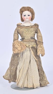 an antique doll of a woman wearing a dress and a hat