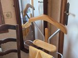 a wooden chair and a towel rack in the corner of a room