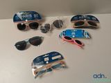 Plusieurs paires de lunettes de soleil et une paire de lunettes de soleil sont posées sur une table