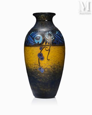 un vase bleu et jaune posé sur une surface blanche