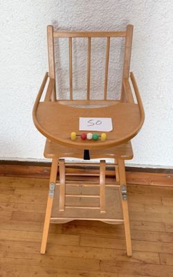une chaise haute en bois avec une pancarte fixée à l'arrière