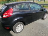 a small black car parked on the side of the road