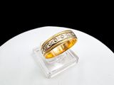 an image of a gold wedding ring on a clear stand