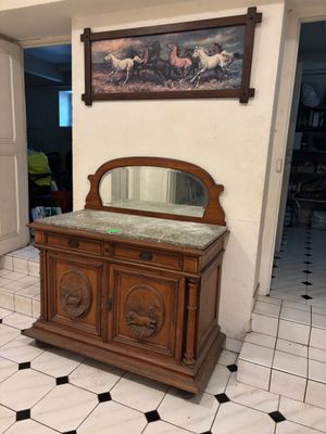 une armoire en bois surmontée d'un miroir, dans une pièce