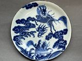 a blue and white plate with a dragon on it