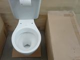 des toilettes blanches posées à côté d'un carton