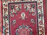 rug on the floor is red and has a medallion design on it
