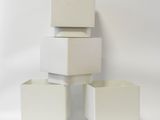 trois boîtes blanches empilées les unes sur les autres sur une surface blanche