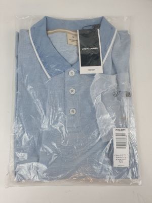 la chemise se trouve dans un sac en plastique posé sur une surface blanche