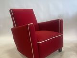 pair of red lounge chairs with white piping on the arms
