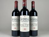 three bottles of red wine sitting next to each other on a table