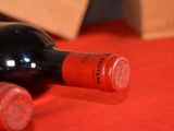 two bottles of wine sitting on a red cloth