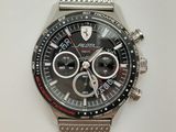 montre argentée avec cadran noir et bracelet en mailles argentées sur fond blanc