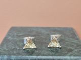 pair of silver and gold plated earrings on a marble box