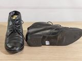 pair of black leather shoes sitting on top of a wooden table