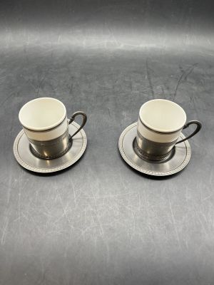 two cups and saucers are sitting on a table