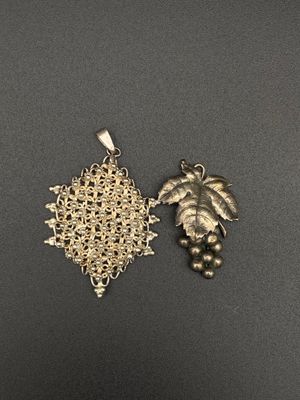 a close up of a silver plated pendant with a palm tree on it