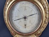 a gold clock on the wall with a black background