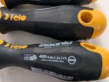 three black and yellow screwdrivers sitting next to each other on a white surface