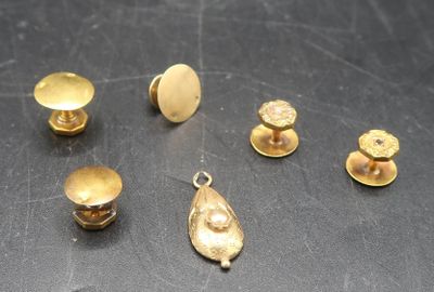 several pieces of gold metal on a table with a black background