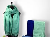 a green scarf and blue scarf on a mannequin stand