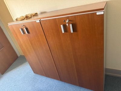 une armoire en bois à deux portes, munie d'une poignée