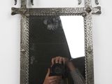 mirror with a silver frame and a person taking a picture