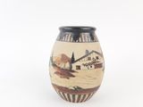 a vase with a painting on it sitting on a table