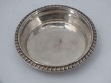 a silver plate on a white table with a white background
