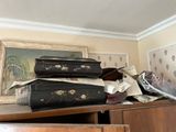 Plusieurs valises sont empilées sur une commode dans une pièce.