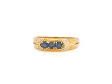 gros plan d'une bague en or avec saphirs bleus et diamants
