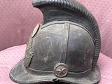 an old fireman ' s helmet is sitting on a pink cloth
