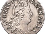 a silver coin with a woman ' s head and a crown on it