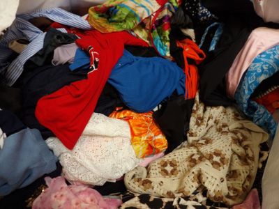 une pile de vêtements posée sur un lit