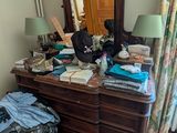 une commode avec un miroir et beaucoup de vêtements dessus