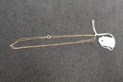 a close up of a gold chain with a heart on it