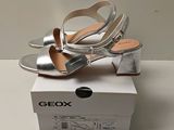 the box is open to show a pair of metallic shoes