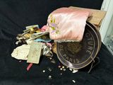 un tas de bric-à-brac posé sur un tissu noir, avec un sac rose