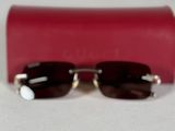 une paire de lunettes de soleil et un étui rouge posés sur une surface blanche