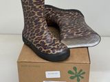 une paire de bottes de pluie à imprimé léopard posée sur une boîte en carton