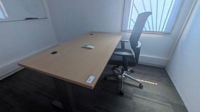 un bureau avec une chaise et une souris posée dessus, dans une pièce