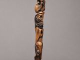 a wooden sculpture of a man with a bird on his head
