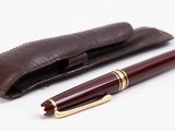 leather pen case with a pen and a ballpoint pen on a white background