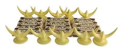 four yellow vases with horns are lined up against a white background
